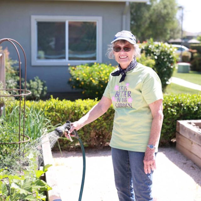 A Bethany resident watering plants in the garden